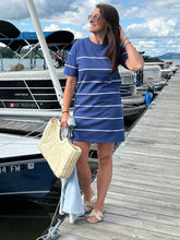 Load image into Gallery viewer, Woman in a striped dress standing on a dock next to a sailboat with a scenic background.