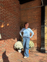 Load image into Gallery viewer, Person lying on a brick floor with potted plants around