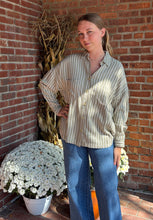 Load image into Gallery viewer, Woman standing against a brick wall with potted plants
